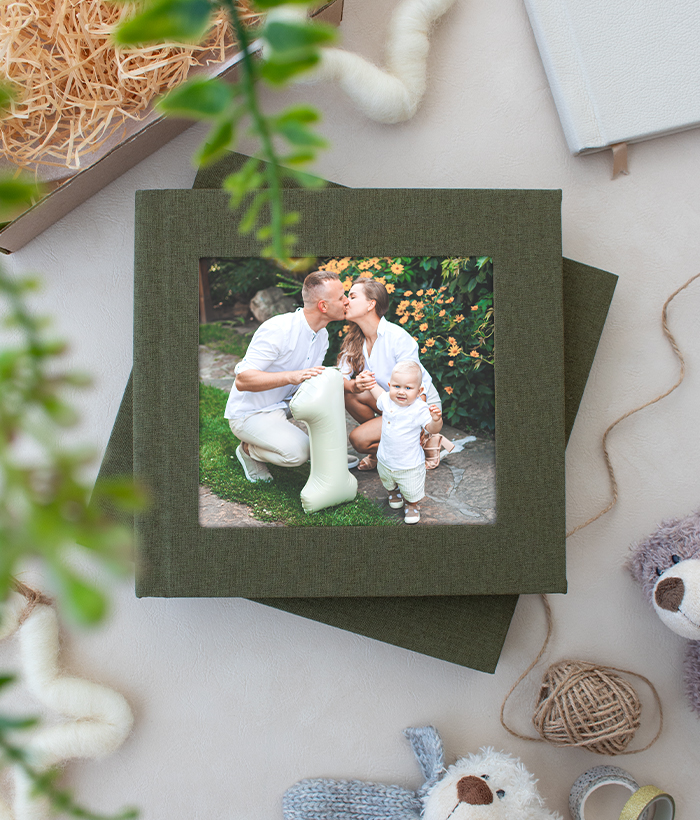 green linen color hard cover photo book on marble table made for pre christmas sale with cameo inset printed photo