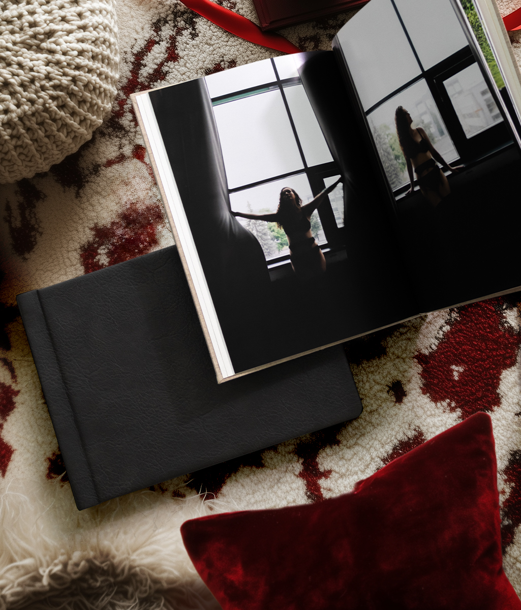 luxury boudoir photo album with black leather cover intimate photography book for personalized gift romantic keepsake on textured rug with red velvet pillow